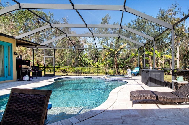 view of pool featuring an in ground hot tub, a lanai, and a patio