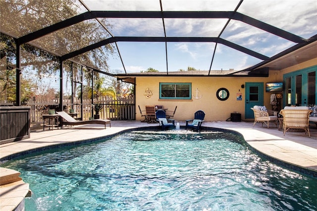 view of pool with a patio, a lanai, and pool water feature