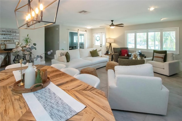 living room with a barn door and ceiling fan