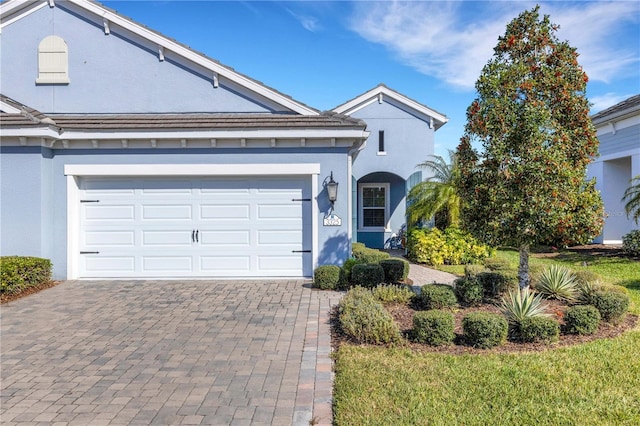 view of front of house featuring decorative driveway and stucco siding