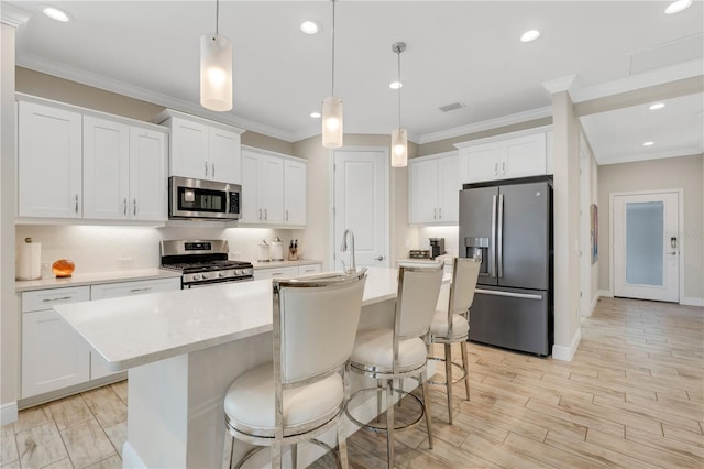 kitchen with appliances with stainless steel finishes, light countertops, and white cabinetry