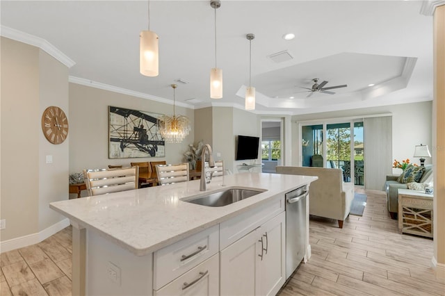 kitchen featuring dishwasher, an island with sink, open floor plan, white cabinetry, and a sink