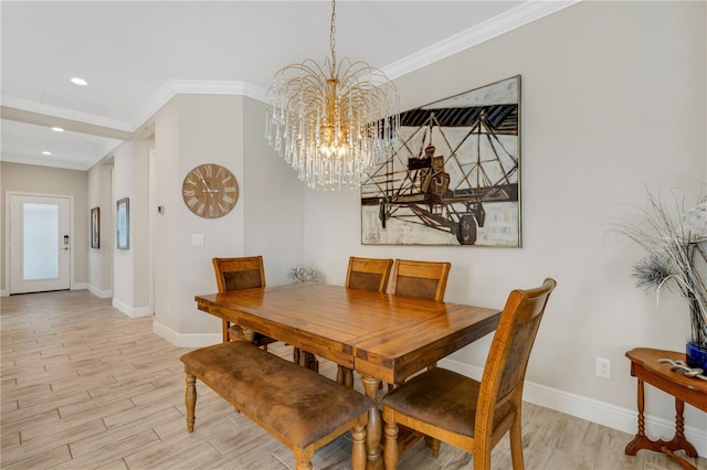 dining space with light wood-style floors, crown molding, baseboards, and an inviting chandelier