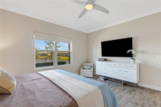 bedroom featuring ornamental molding, light wood-type flooring, baseboards, and a ceiling fan