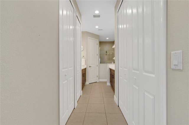 hallway with recessed lighting, visible vents, baseboards, and light tile patterned flooring