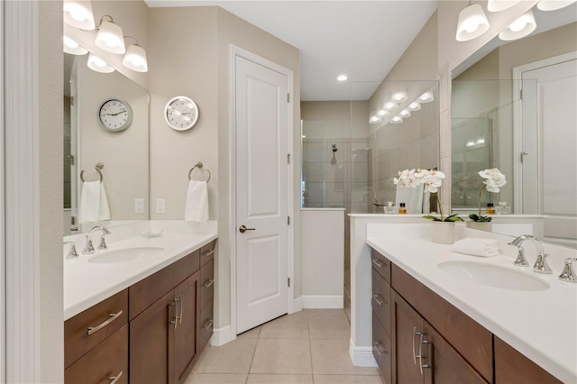 bathroom with tile patterned floors, two vanities, a sink, and walk in shower