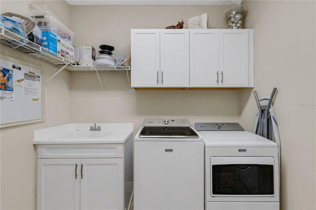 laundry area featuring washer and clothes dryer, a sink, and cabinet space