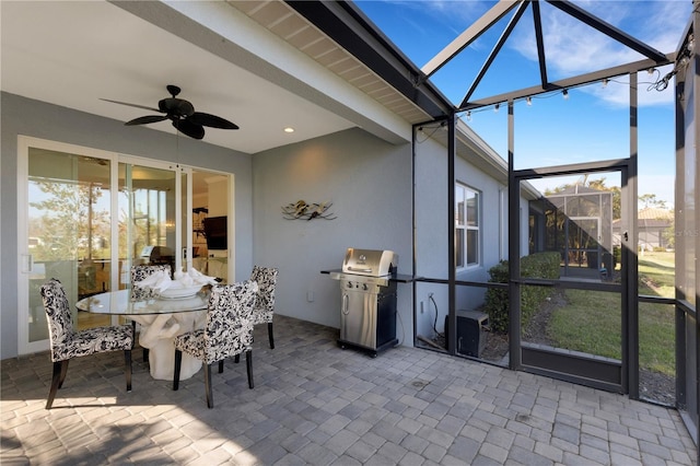 sunroom / solarium featuring a ceiling fan and beam ceiling