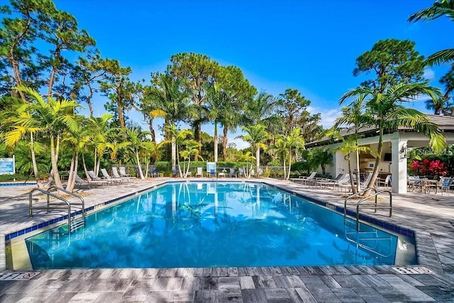 pool with a patio area and fence