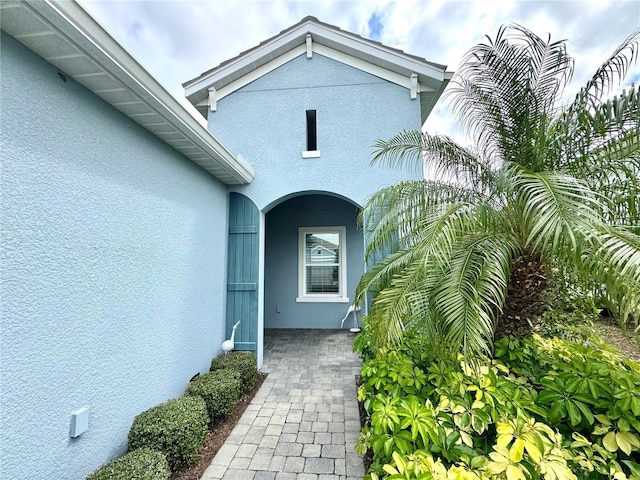 view of exterior entry with stucco siding