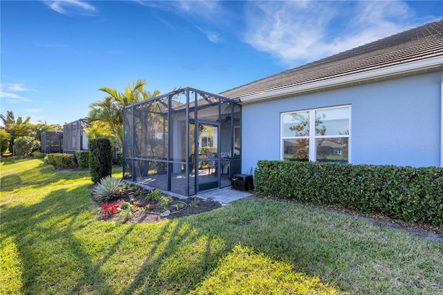 3325 Azurite Way, Bradenton, FL 34211 - rear view of house featuring stucco siding, a yard, glass enclosure, and a patio