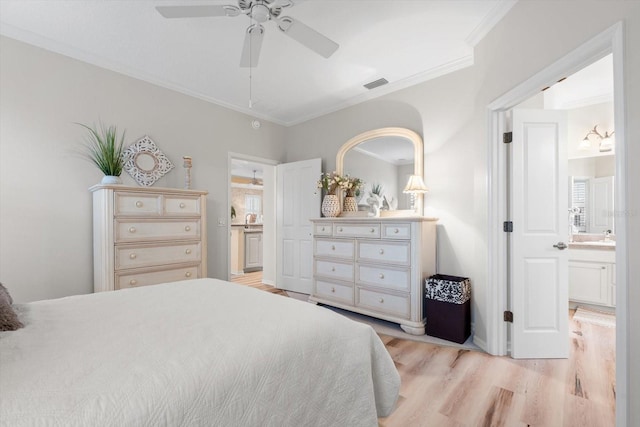 bedroom featuring ornamental molding, ensuite bathroom, ceiling fan, and light wood-type flooring