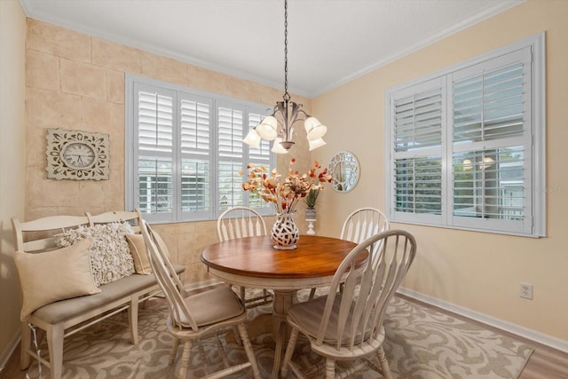 dining area featuring a notable chandelier, wood-type flooring, and ornamental molding