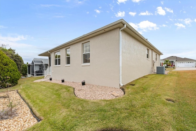 view of home's exterior featuring a yard, central AC unit, and glass enclosure