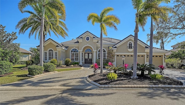 mediterranean / spanish house with a garage and french doors