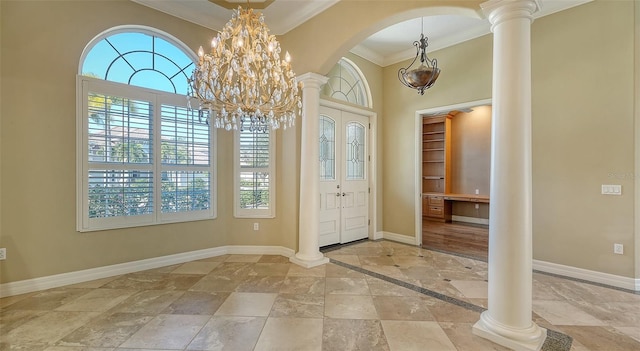 entrance foyer with ornamental molding, decorative columns, and a notable chandelier