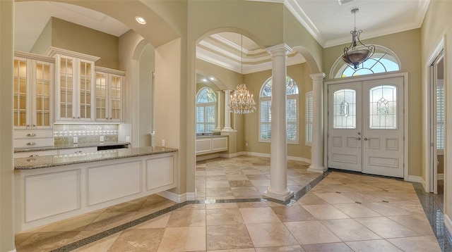 entrance foyer with crown molding and decorative columns