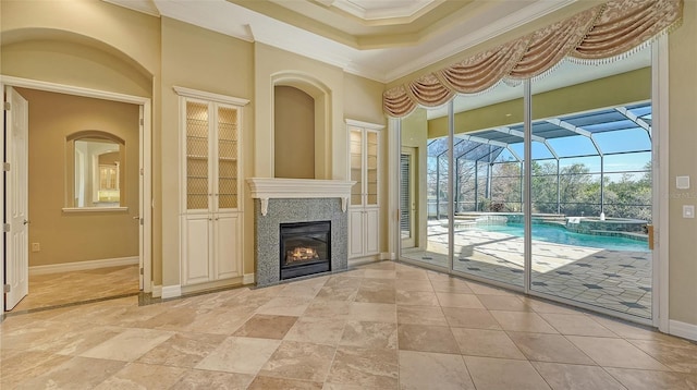 unfurnished living room featuring crown molding, a fireplace, and a raised ceiling