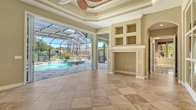 interior space featuring crown molding, ceiling fan, and a high ceiling