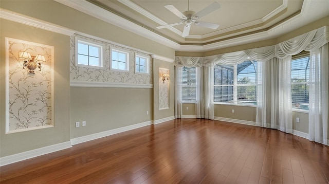 empty room with hardwood / wood-style floors, ornamental molding, a raised ceiling, and ceiling fan