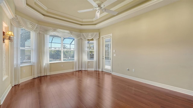 spare room with hardwood / wood-style flooring, crown molding, ceiling fan, and a tray ceiling