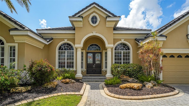 13616 Legends Walk Ter, Lakewood Ranch, FL 34202 - view of exterior entry with french doors, stucco siding, an attached garage, and a tile roof