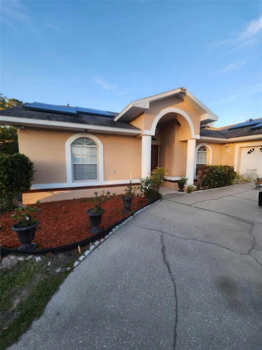 view of front of house featuring a garage and solar panels