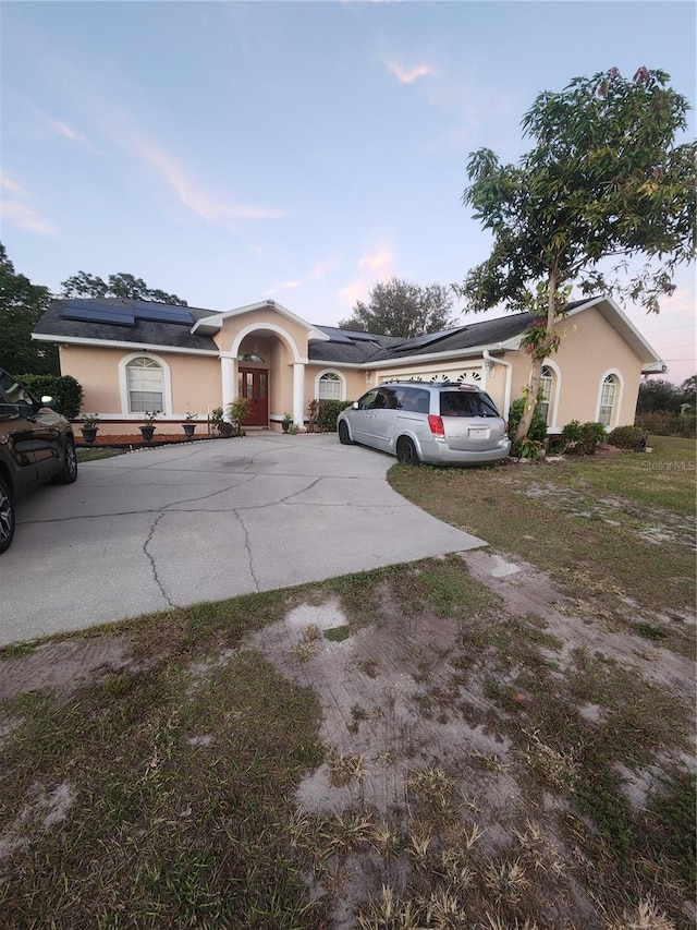 single story home featuring a garage and solar panels