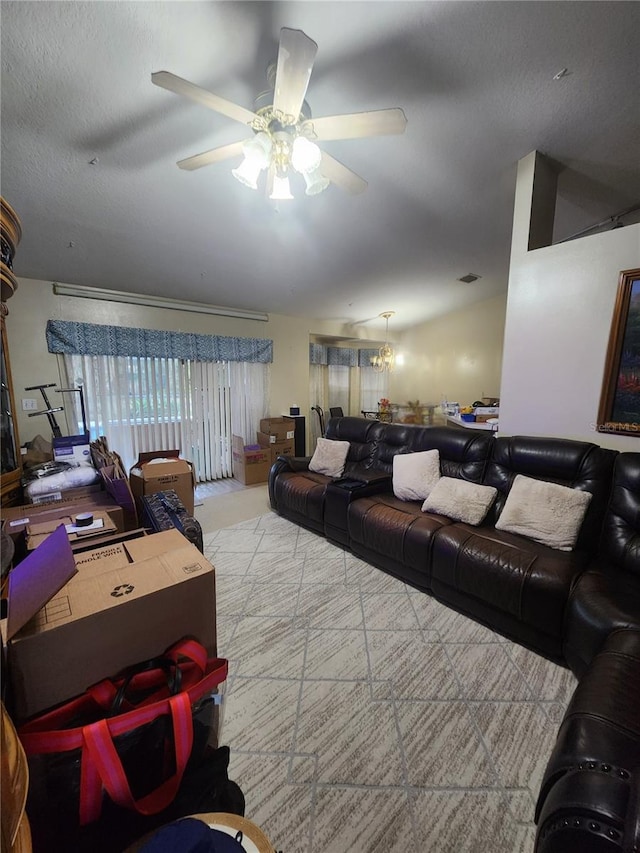 living room featuring ceiling fan and a textured ceiling