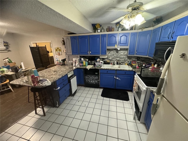 kitchen featuring white appliances, blue cabinets, sink, and light tile patterned floors