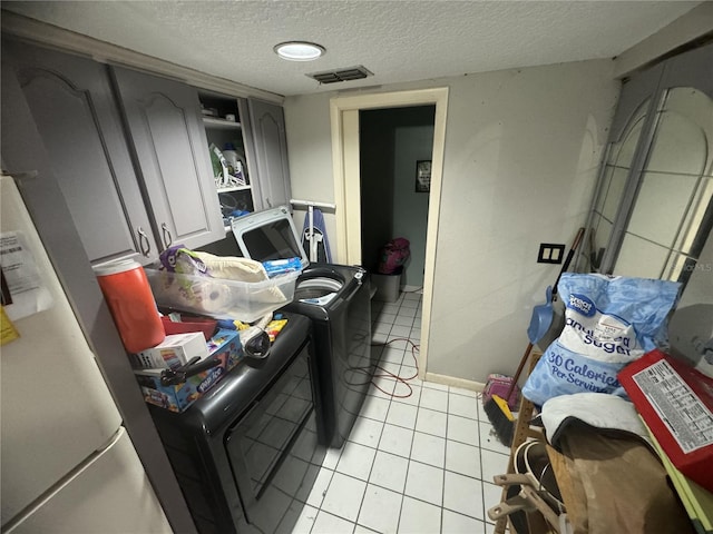 living room featuring light tile patterned floors, independent washer and dryer, and a textured ceiling