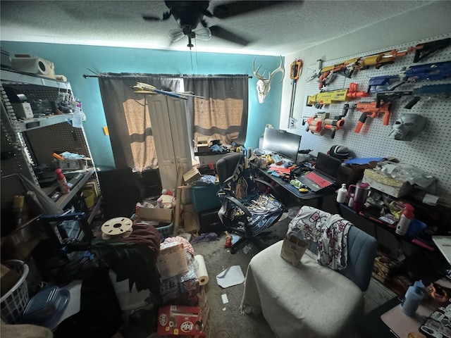 miscellaneous room with ceiling fan and a textured ceiling