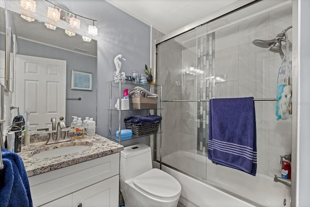 full bathroom featuring vanity, crown molding, shower / bath combination with glass door, and toilet