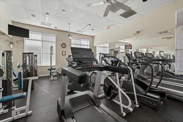 workout area featuring ceiling fan and a drop ceiling