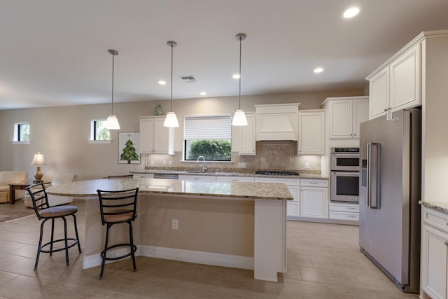 kitchen with stainless steel appliances, custom range hood, a kitchen island, and white cabinets