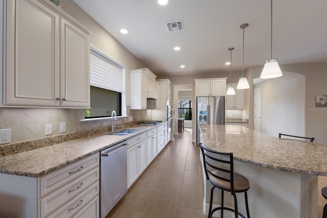 kitchen featuring stainless steel appliances, a kitchen island, a breakfast bar, and pendant lighting