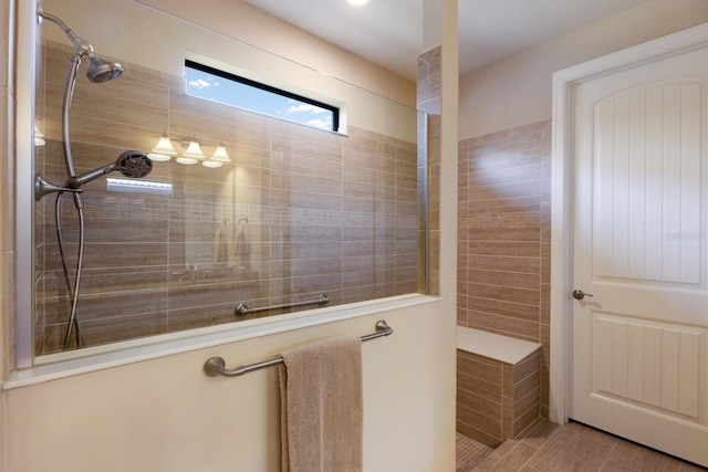 bathroom with tile patterned flooring and a tile shower