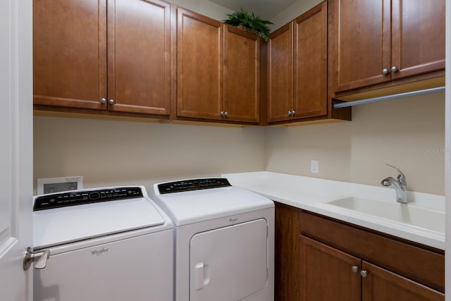 laundry area featuring cabinets, sink, and washer and clothes dryer