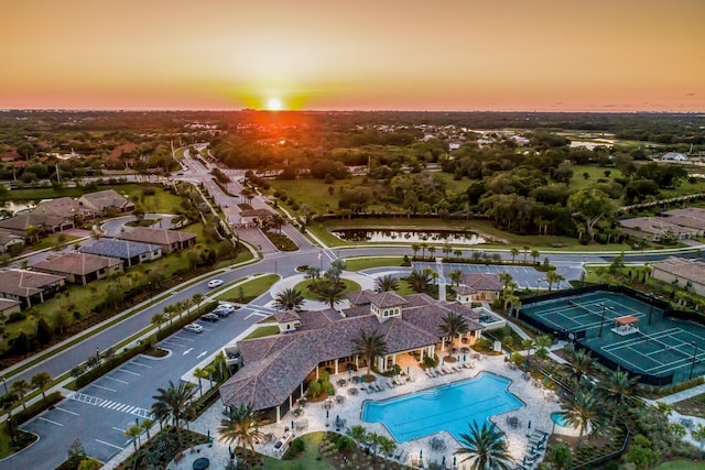 aerial view at dusk featuring a water view