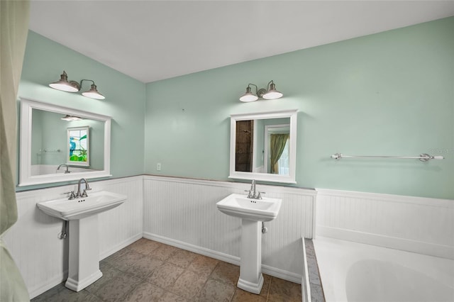 full bath featuring a wainscoted wall and a washtub