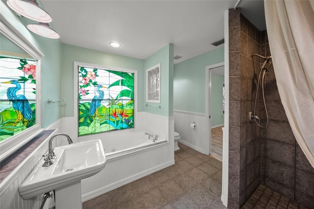 full bath featuring visible vents, toilet, a wainscoted wall, walk in shower, and a bath