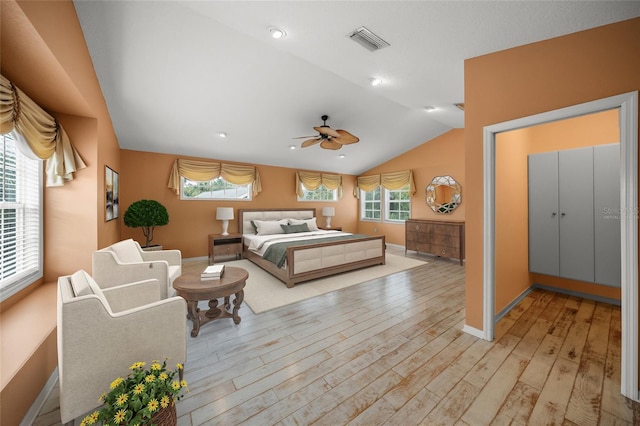 bedroom with light wood finished floors, baseboards, visible vents, lofted ceiling, and ceiling fan