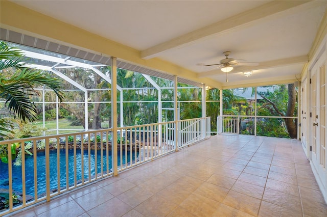 unfurnished sunroom featuring ceiling fan and beam ceiling