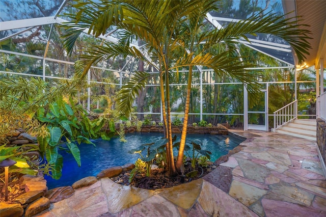 view of swimming pool featuring a small pond, a lanai, and a patio