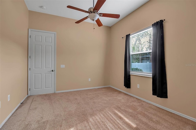 unfurnished room with ceiling fan and light carpet