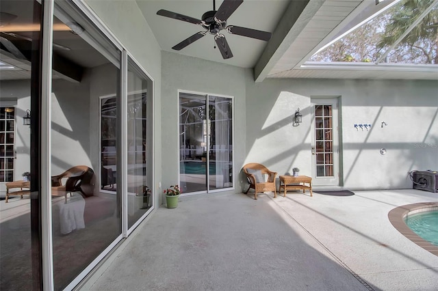 view of patio with ceiling fan and glass enclosure