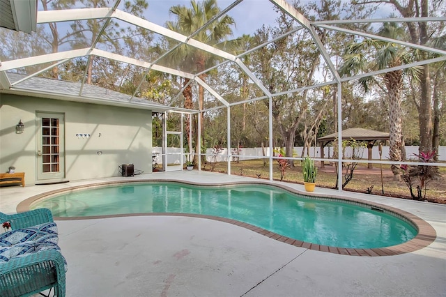 view of pool with a gazebo, a patio area, and glass enclosure