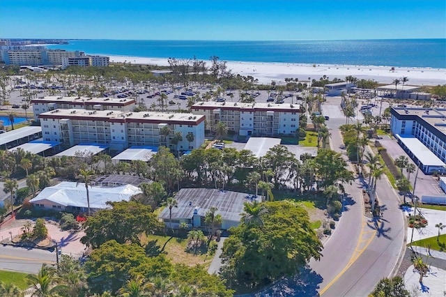 drone / aerial view featuring a beach view and a water view