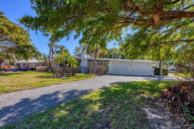 single story home with a garage and a front lawn