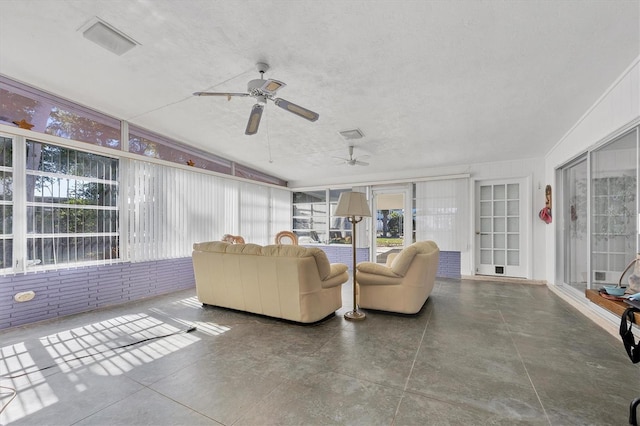 living room featuring a textured ceiling and ceiling fan